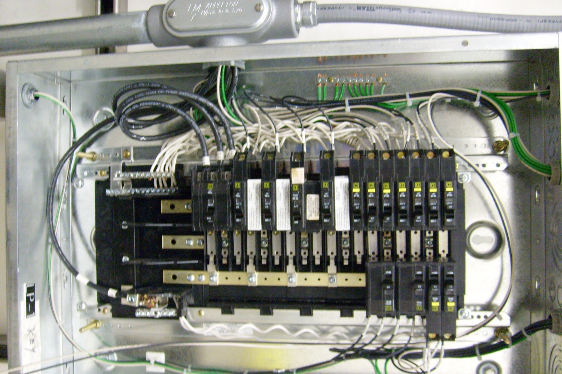 Electrical panel interior with breakers and routed conductors